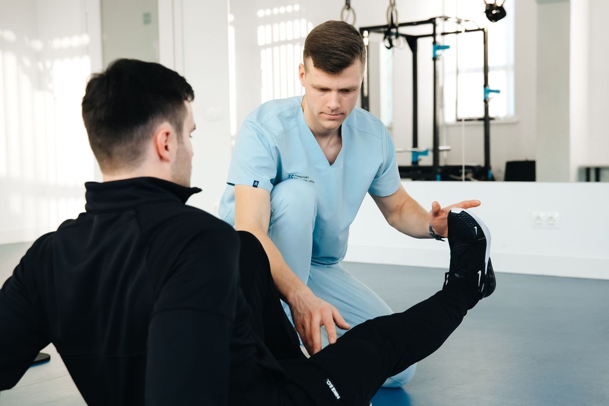 A physiotherapist supporting a patient's leg during an orthopaedic assessment